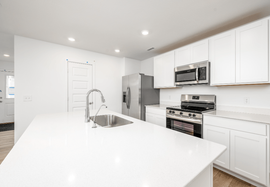 A modern kitchen with white cabinets and appliances.