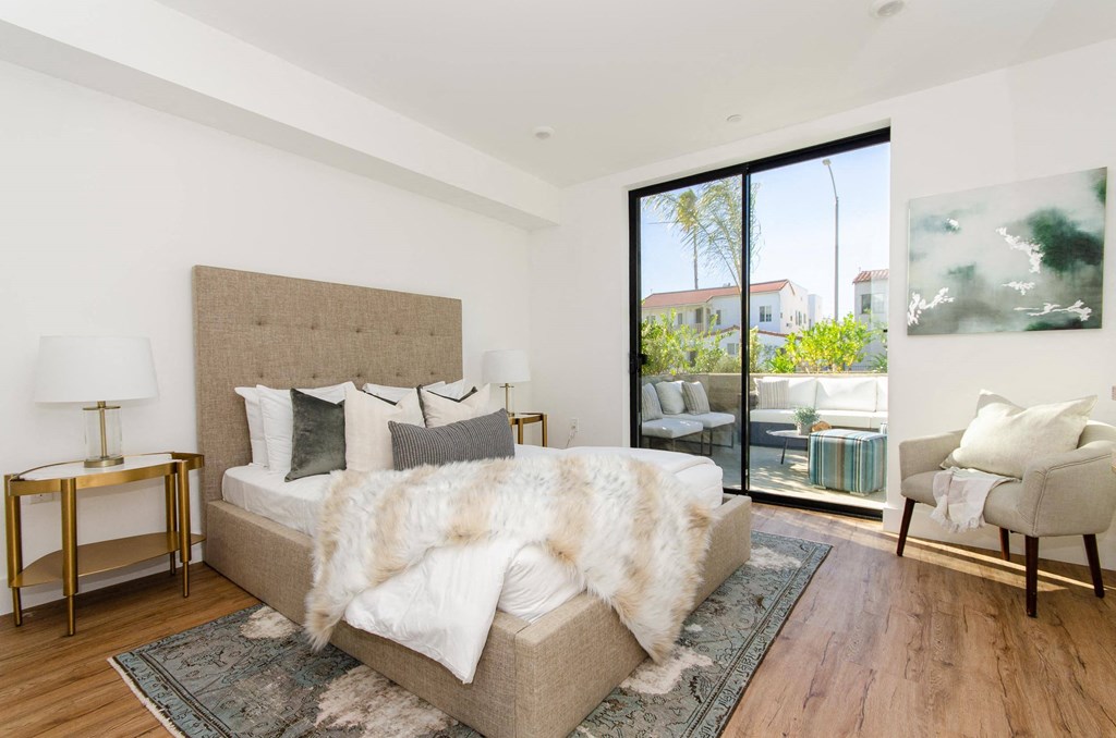 A bedroom with a large bed and a chair.