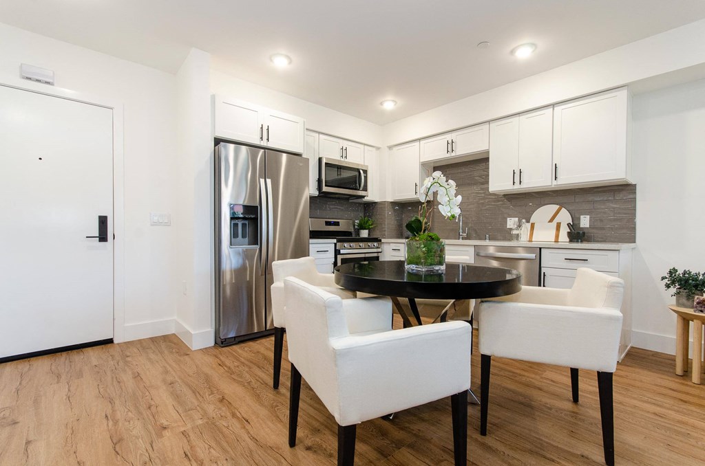 A modern kitchen with a dining table and chairs.