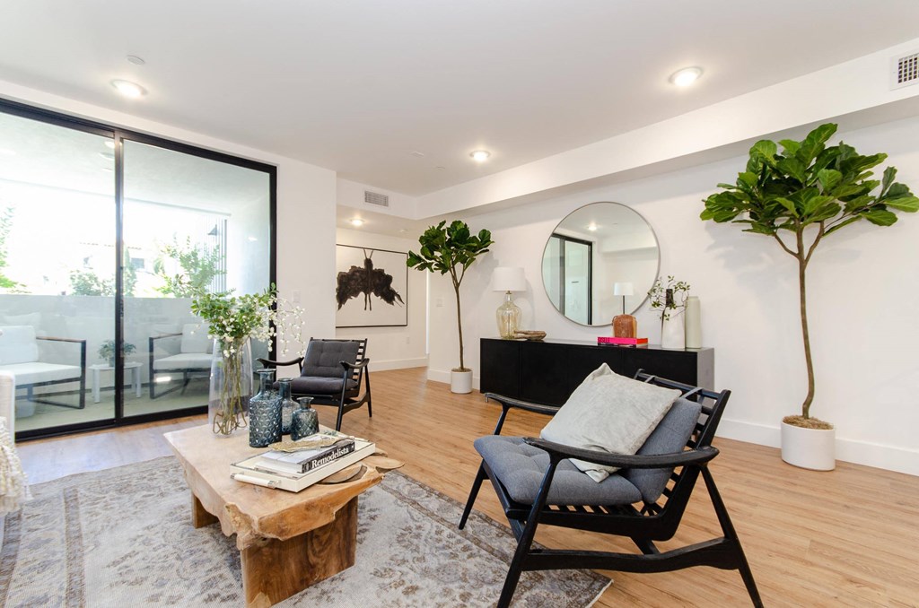 A living room with a black chair and a wooden coffee table.