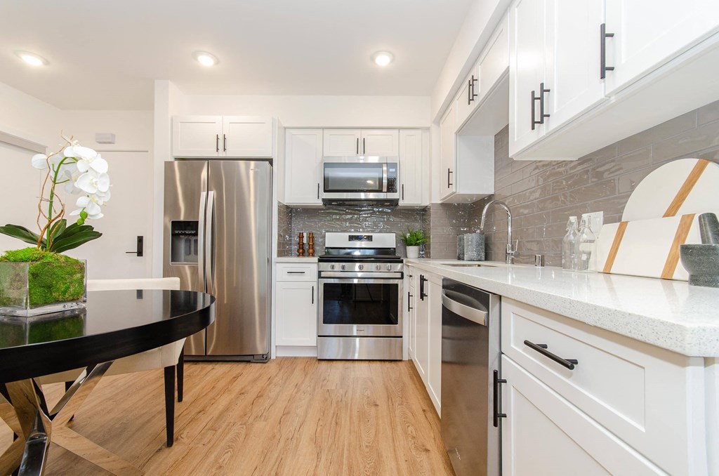 A modern kitchen with white cabinets and a black table.