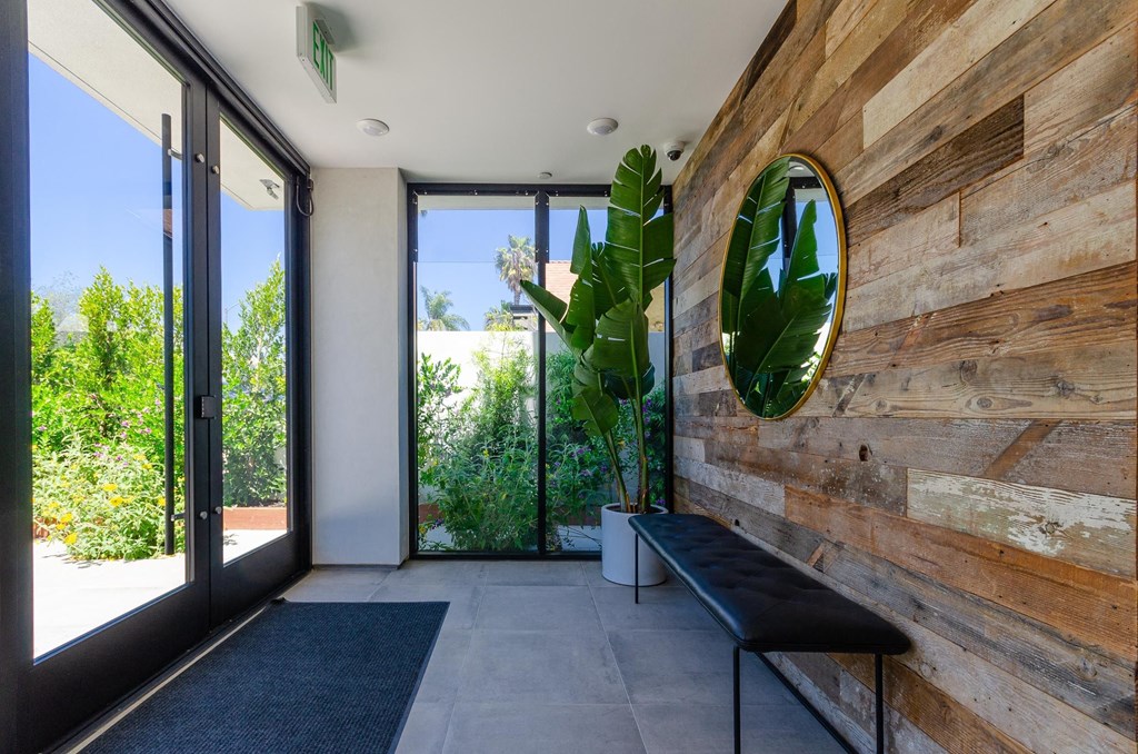 A wooden wall with a mirror and bench in front of it.