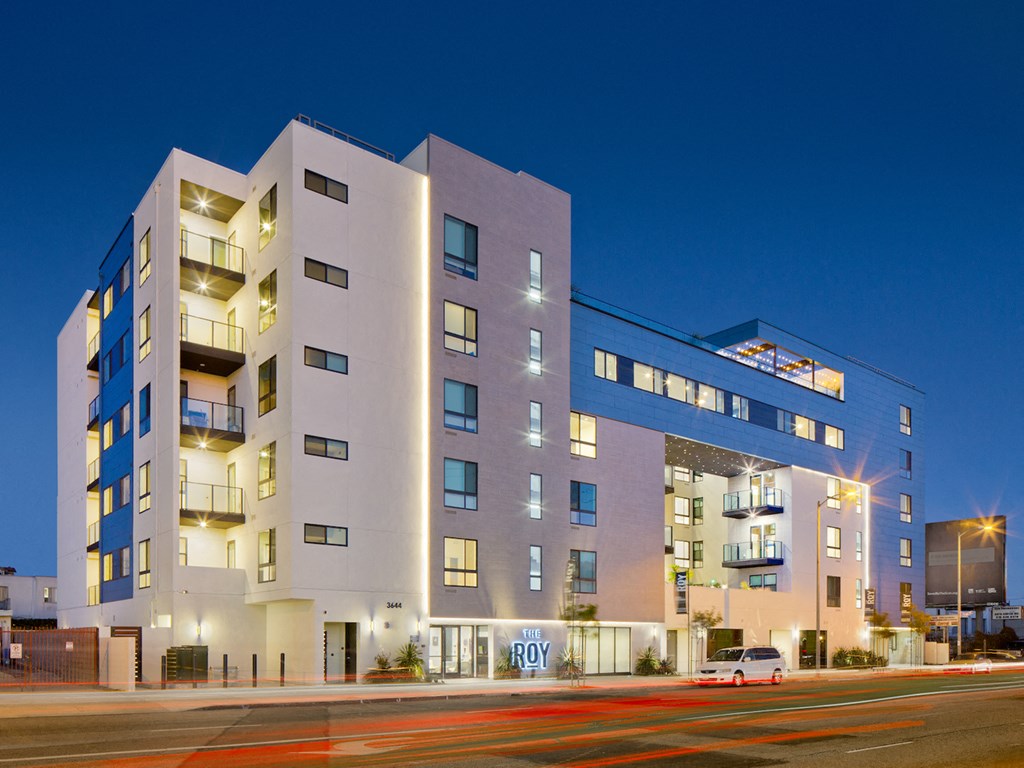A image of The Roy apartment building with a lit up sign that says