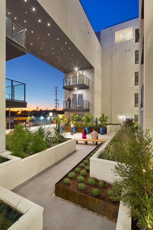 A modern courtyard with a bench and plants.