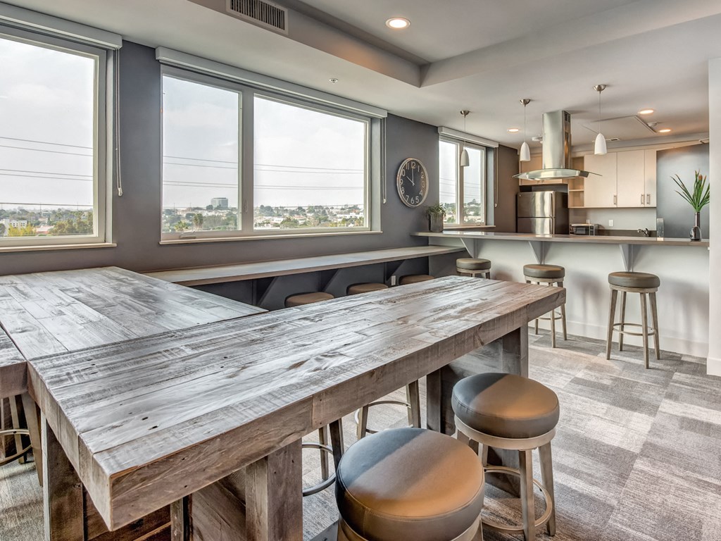 A kitchen with a large wooden table and bar stools.