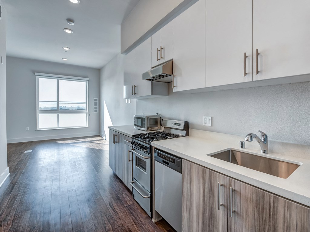 A kitchen with a stove, oven, and sink.