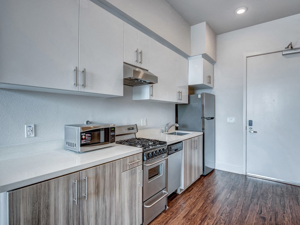 A kitchen with white cabinets and a stainless steel refrigerator.