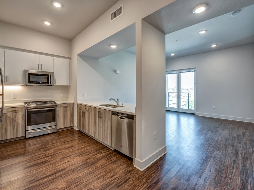 A kitchen with wood floors and a large window.