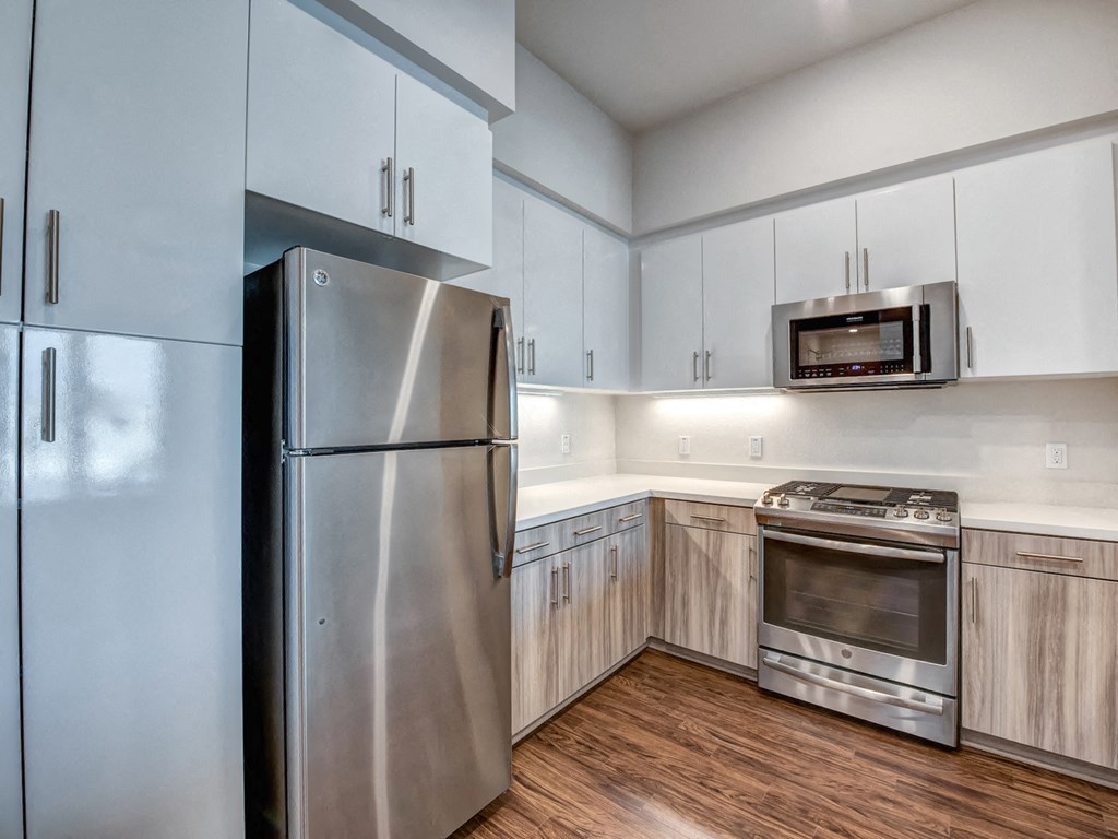 A modern kitchen with a stainless steel refrigerator and oven.