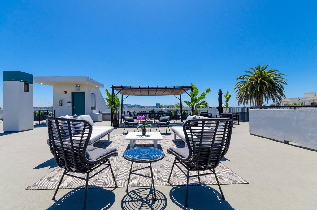A patio with chairs and a table is set up on a sunny day.