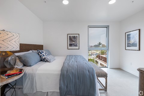A bedroom with a large bed and a view of the outside.