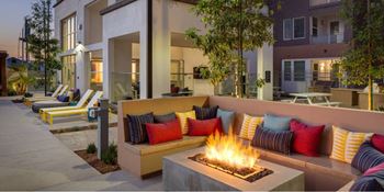 A patio with a fire pit and couches.