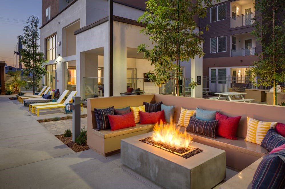 A modern outdoor seating area with a fire pit in the center.