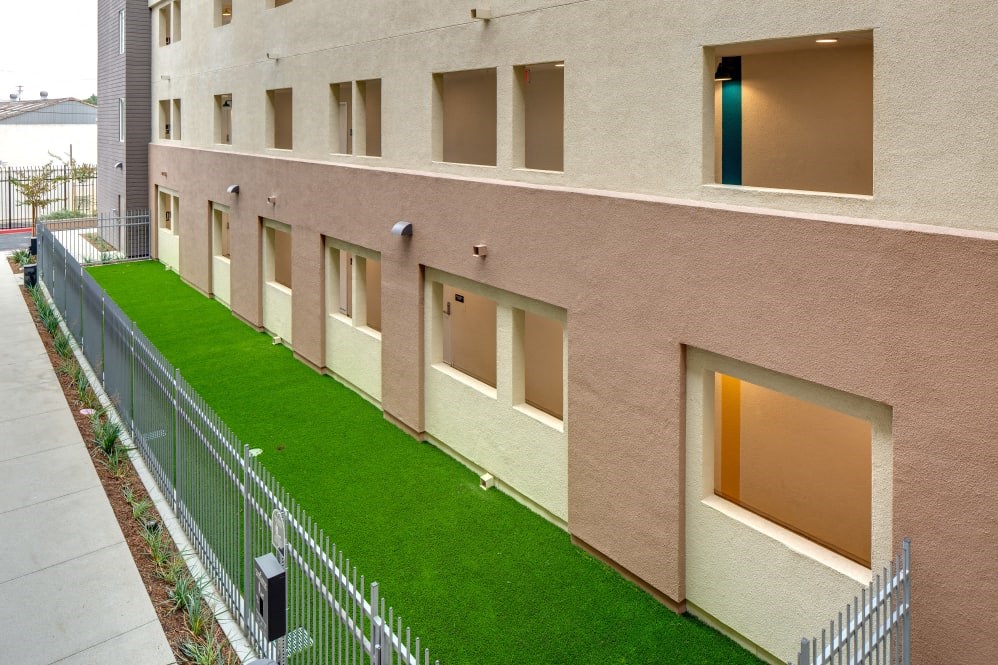 A building with a green lawn in front.