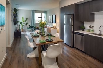 A modern kitchen with a dining table and chairs.