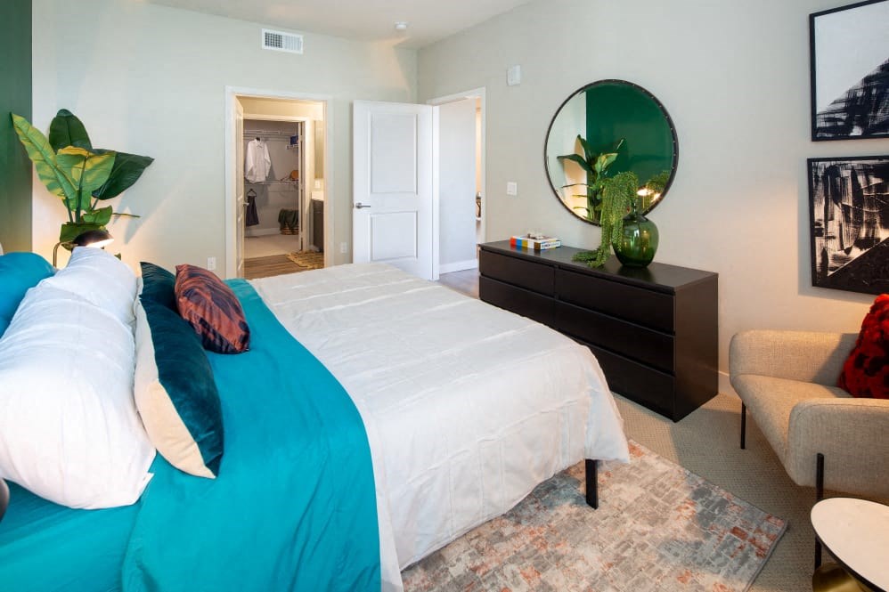 A bedroom with a large bed and a mirror on the wall.