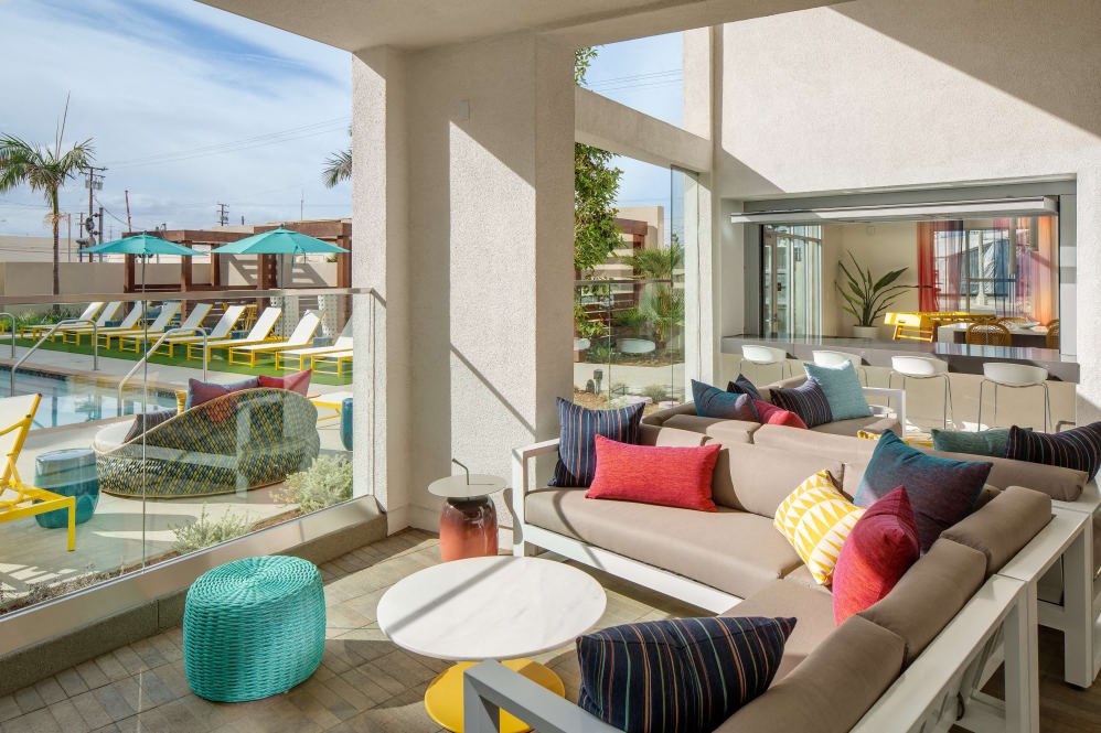 A sunny day at the poolside with a comfortable seating area.