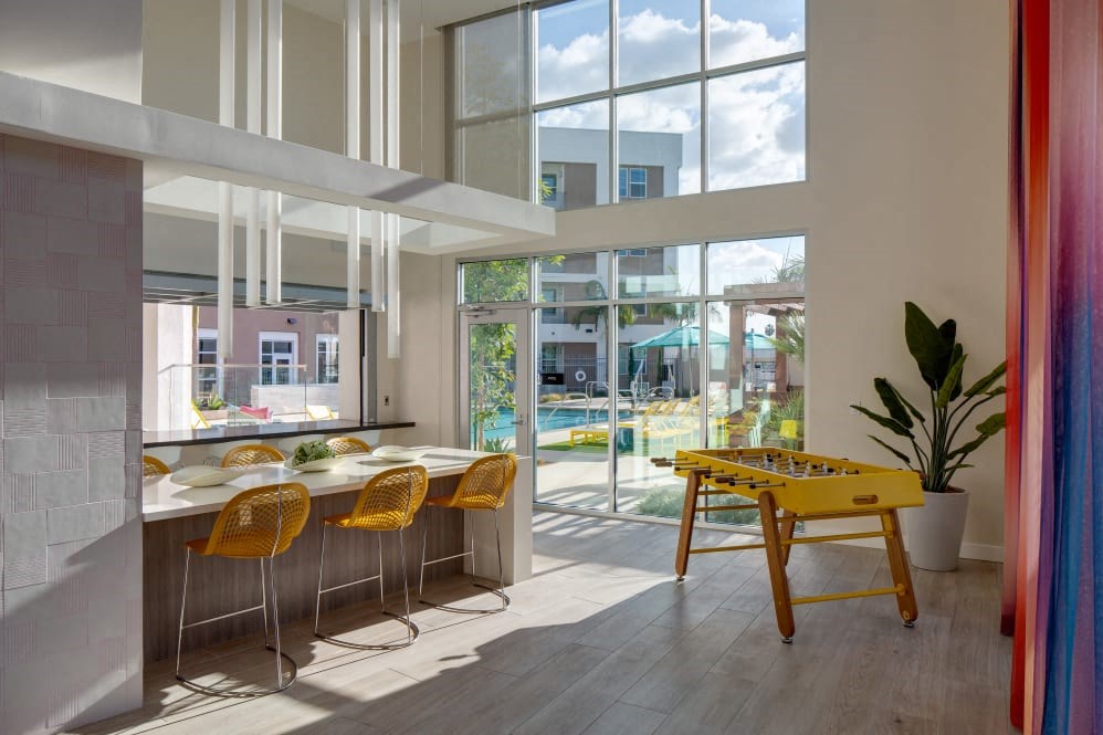 A brightly lit room with a yellow table and chairs.