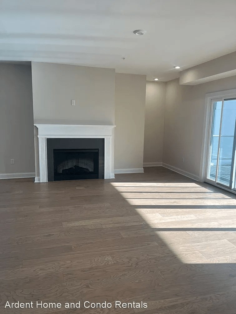 a living room with a fireplace and wooden floors