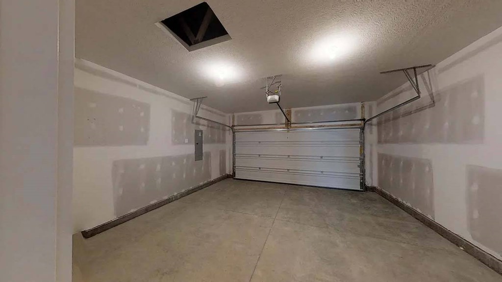 an empty garage with a white wall and a garage door