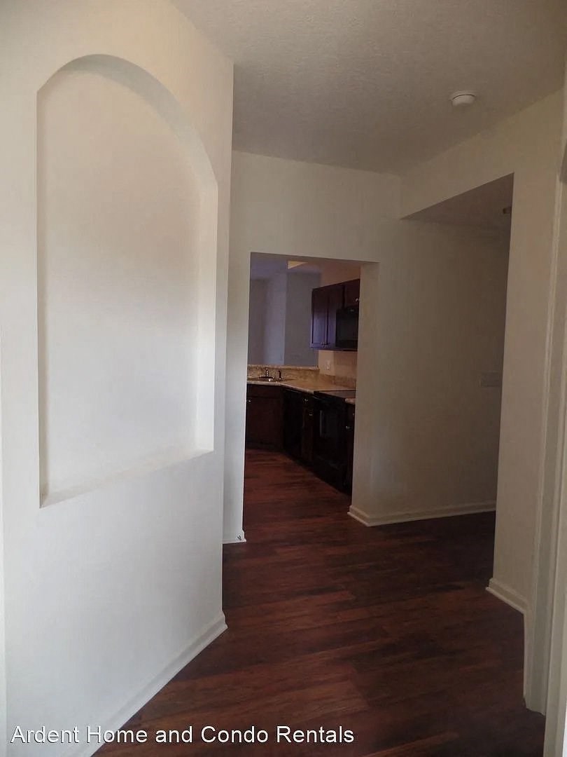 a view of a kitchen and a hallway with a hard wood floor