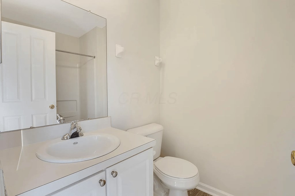 a white bathroom with a toilet and a sink