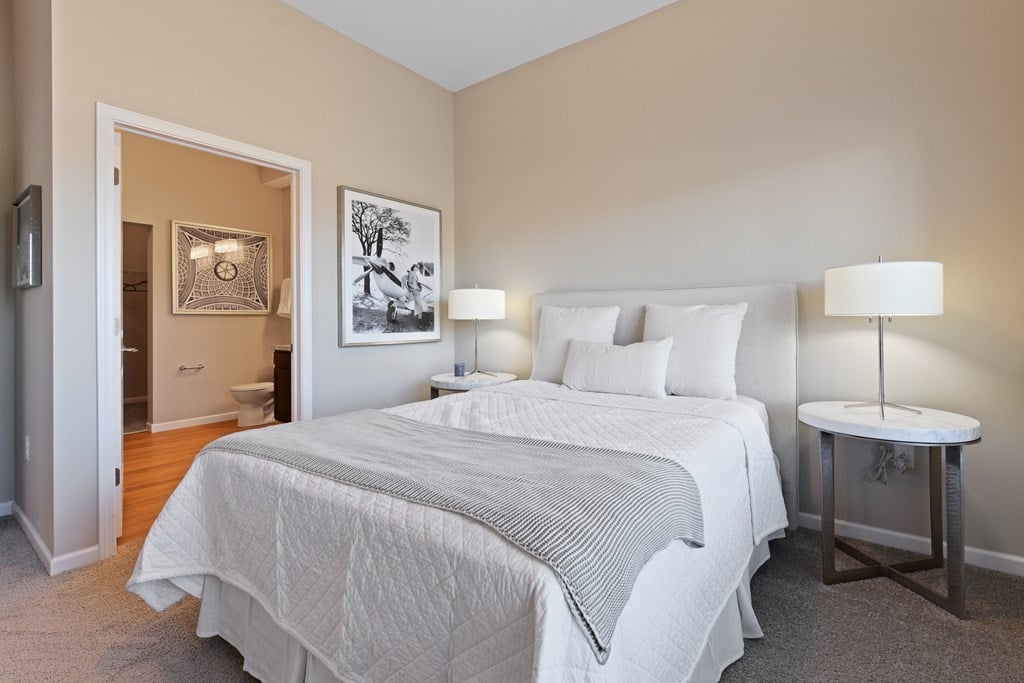 A bedroom with a large bed and a small table.