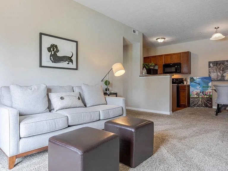 a living room with a white couch and a kitchen