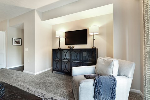 A living room with a grey couch and a black cabinet.