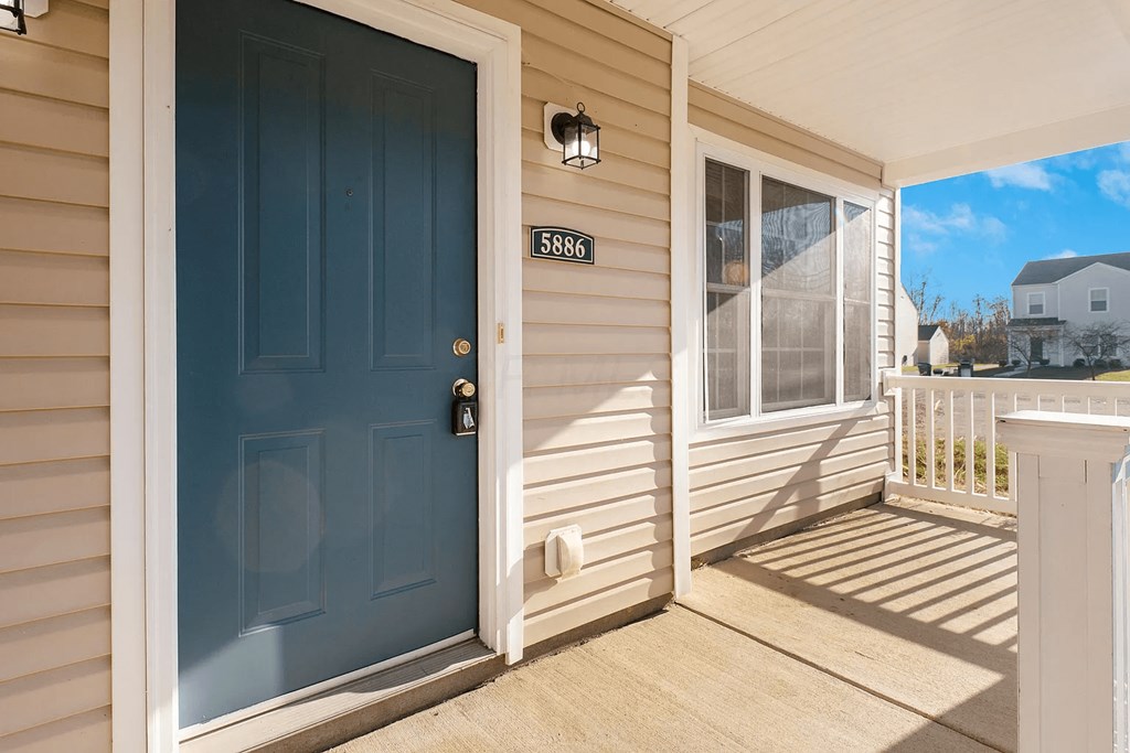 A blue door with a mailbox on the side of a house.