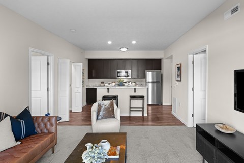 A modern living room with a brown leather couch and a coffee table in the center.