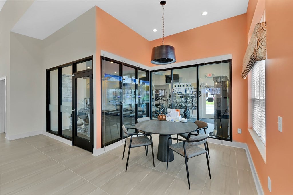 A modern dining room with a glass table and chairs.
