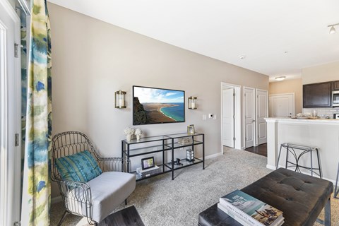 A living room with a chair, a table, and a painting on the wall.