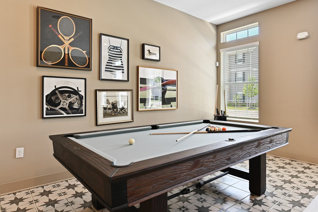 A pool table with a white cloth and a cue stick on it.