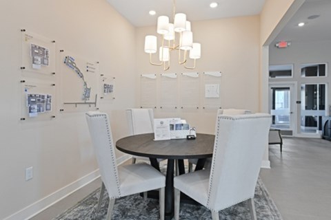 A dining room with a round table and four chairs.