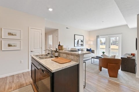 A kitchen with a marble countertop and a dining area with a table and chairs.