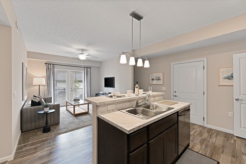 A modern kitchen with a large island and a living area with a couch and a coffee table.