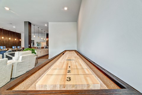 A long wooden table with numbers 1, 2, and 3 on it is in the foreground of an indoor space.