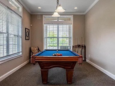a room with a pool table and a window