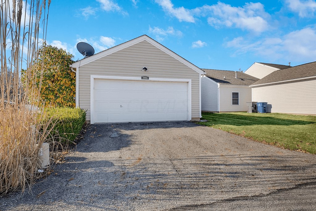 a white house with a white garage door and a driveway