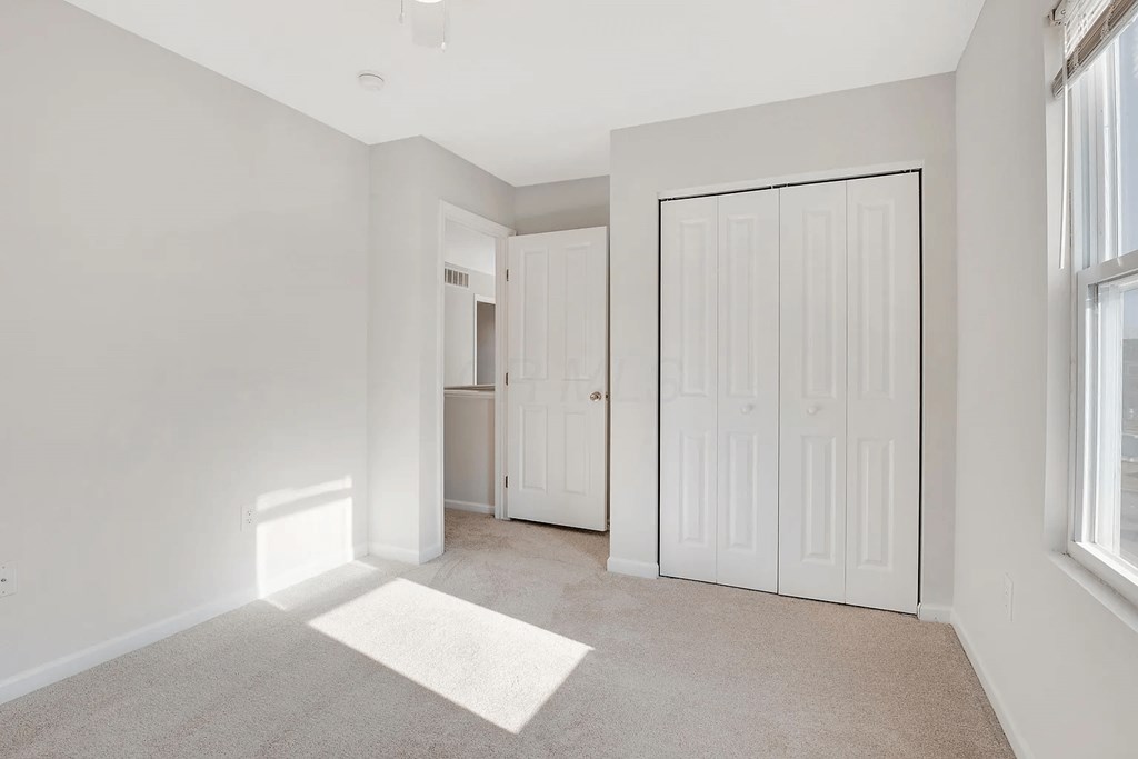 A room with a white door and a white wall.