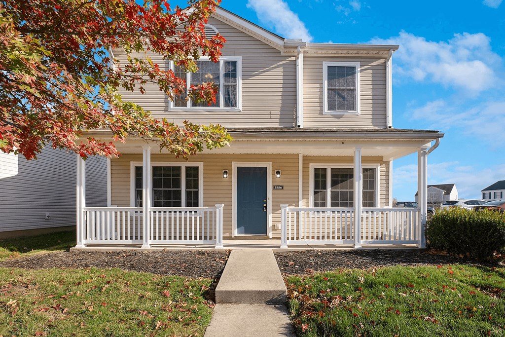 A house with a blue door and white fence.