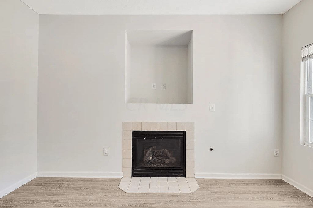 A white room with a fireplace and a window.