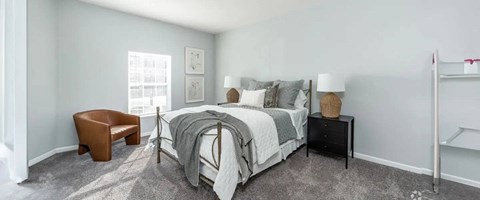 a bedroom with a bed and a chair and a window