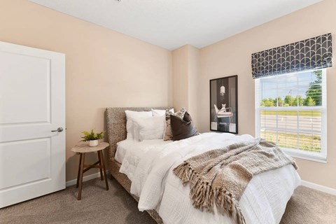 A bedroom with a large bed and a window with a view of the outside.