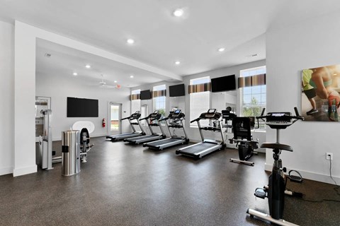 A spacious gym with treadmills, elliptical machines, and a stationary bike.