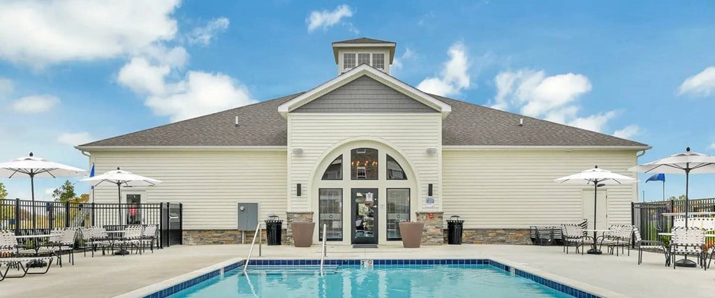 A large white building with a pool in front.