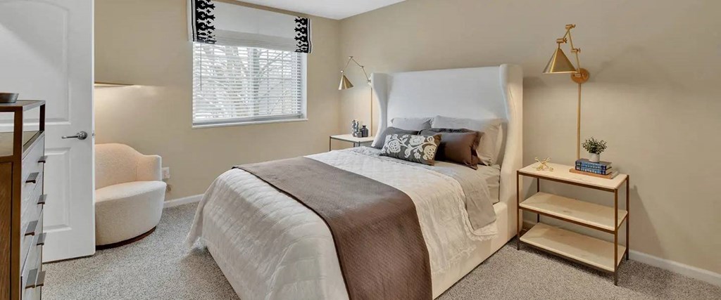 a bedroom with a large bed and a chair