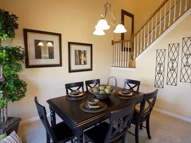 A dining room with a table set for four.