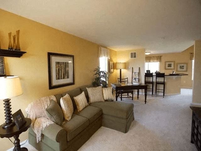 A living room with a couch, a table, and a chair.